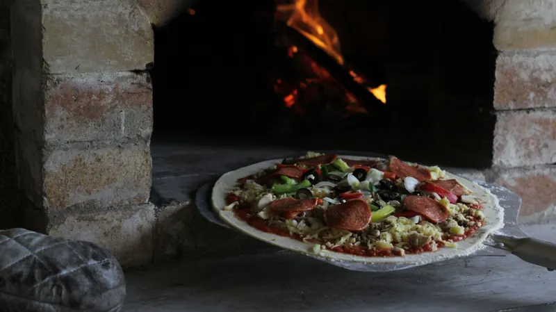 Authentic pizza baking in a traditional stone oven in Indonesia