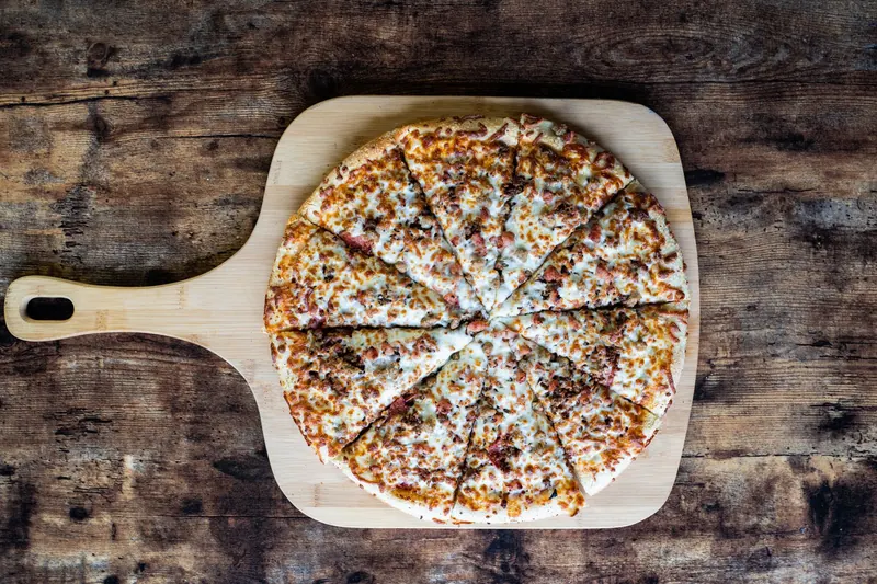 Top view of a cheesy pizza on a wooden board, perfect for food photography
